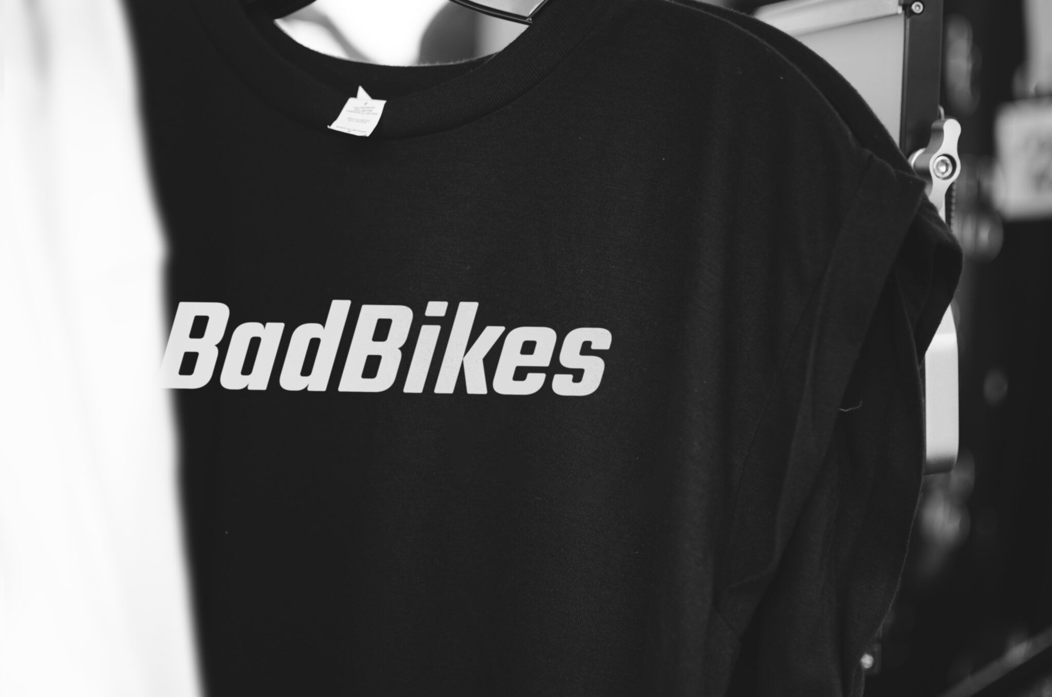 Das schwarz-weiße Bild zeigt ein Logo des Fahrradladens Bad Bikes Berlin auf einem schwarzen T-Shirt