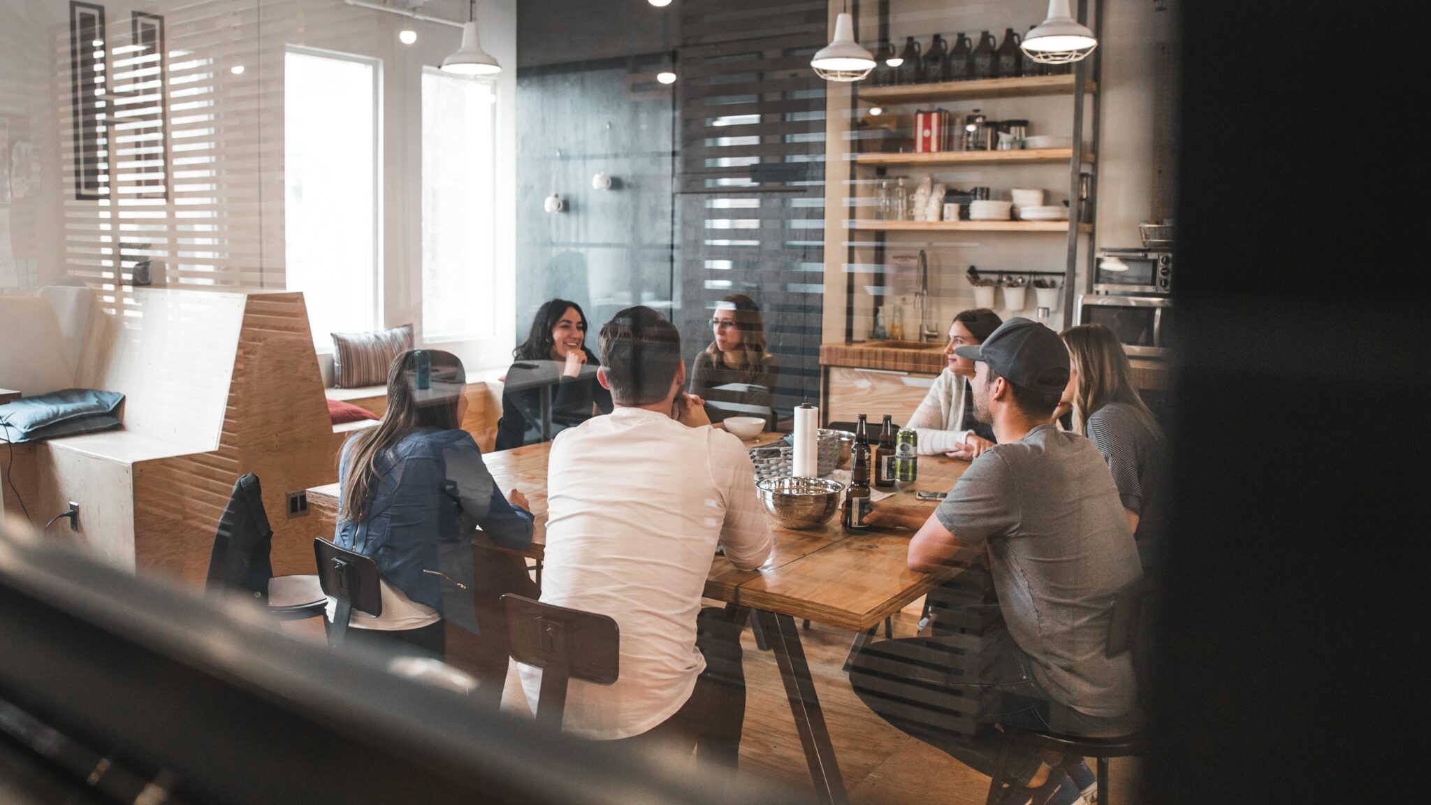 An image showcasing a team meeting, with team members sitting in a circle around a meeting table and engaged in discussion. The image style features elements that are consistent with the branding for Highperforming Team, such as a focus on teamwork, collaboration, and effective communication. The image serves as an example of the visual style used in the branding for Highperforming Team.