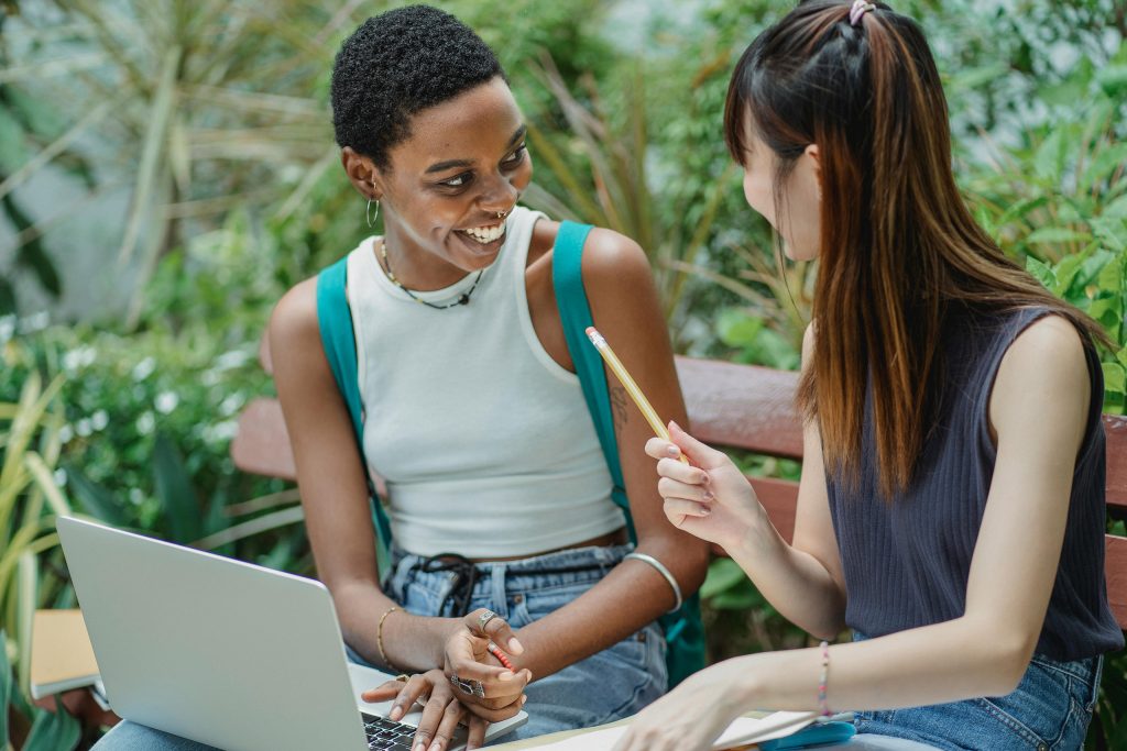 Two women brainstorming and laughing. This image is to introduce my article "How to create a strong brand name in 7 steps)