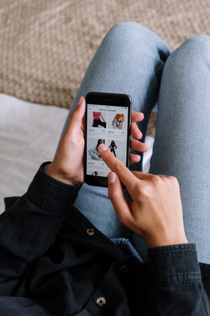 woman who is online shopping looks at her phone screen as an example for cognitive biases in decision-making