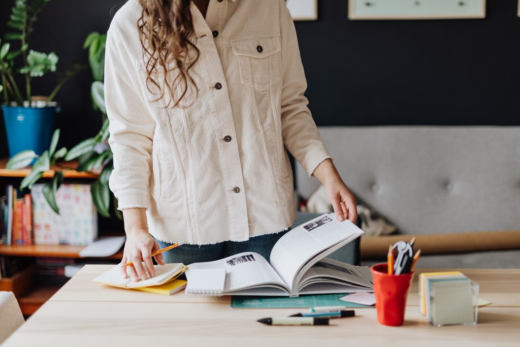 Freelancer working on her desk. This image introduces the article 'Branding Agency vs Freelance Brand Designer: Which is Right for Your Business?'