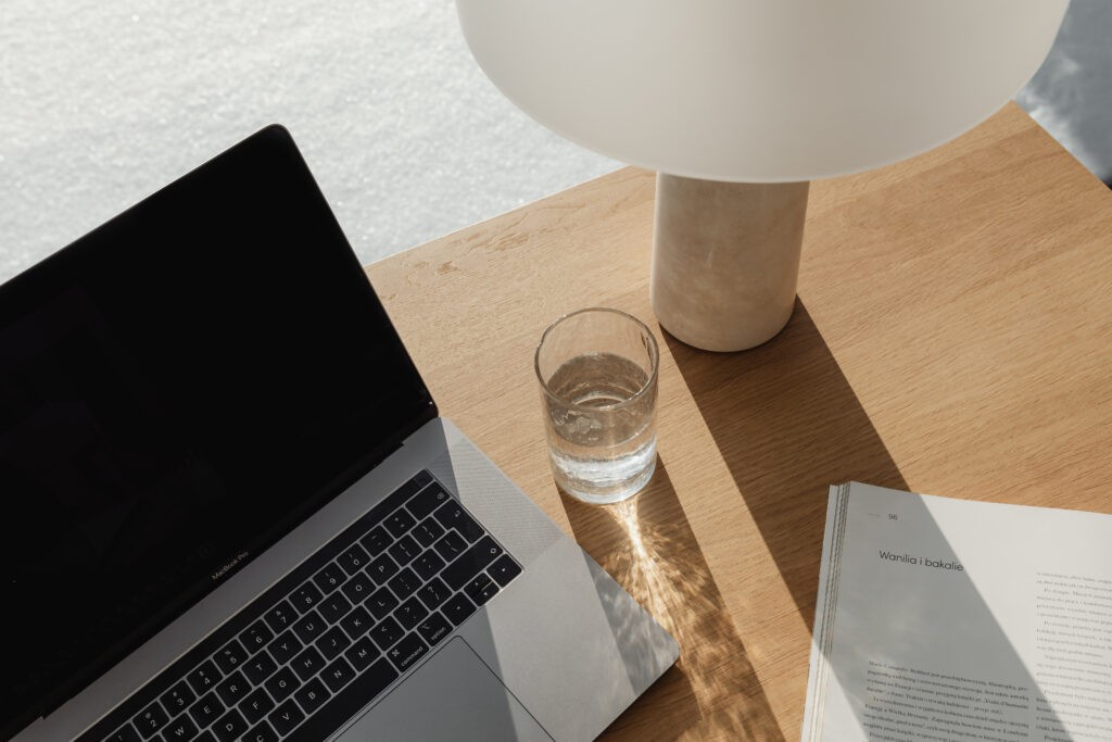 the image shoes a laptop, a lamp and a glass of water on a desk. It’s an introduction to the blog post "When is the best time for branding?"