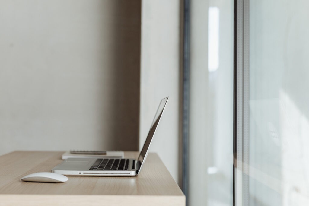 A laptop in front of a window. its the title image for a blog post about creating a great brand name.