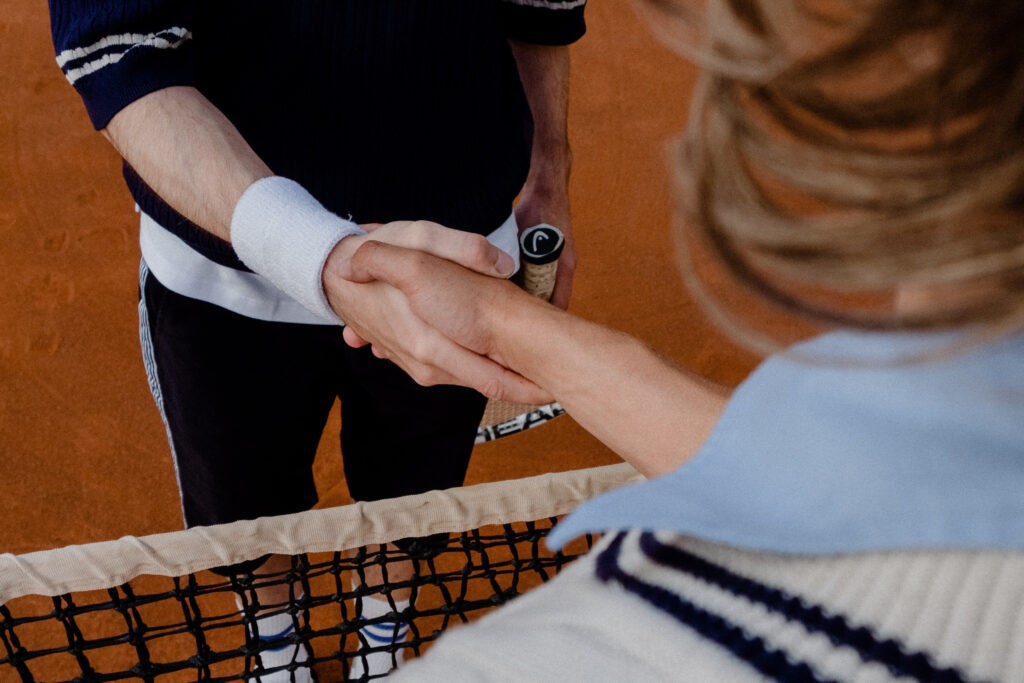 Two tennis players shaking hands over the net as a metaphor for co-branding