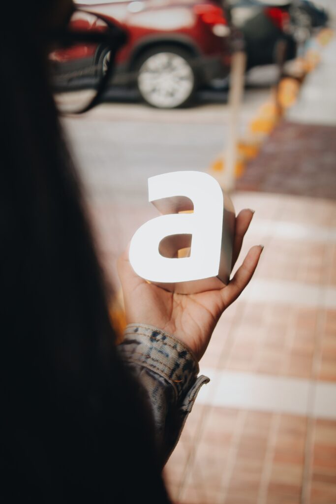 Woman holding the letter 'a'. This is the title image for a comprehensive article on choosing brand fonts.