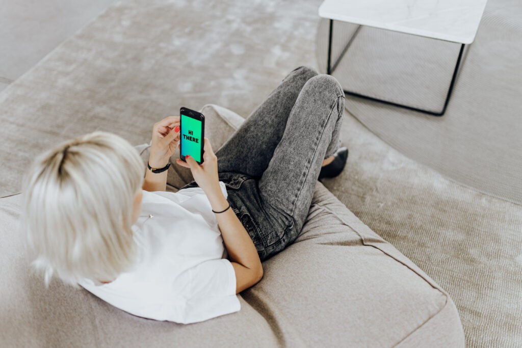 Woman looking at her mobile screen at a welcome message. This is an example of brand touchpoints