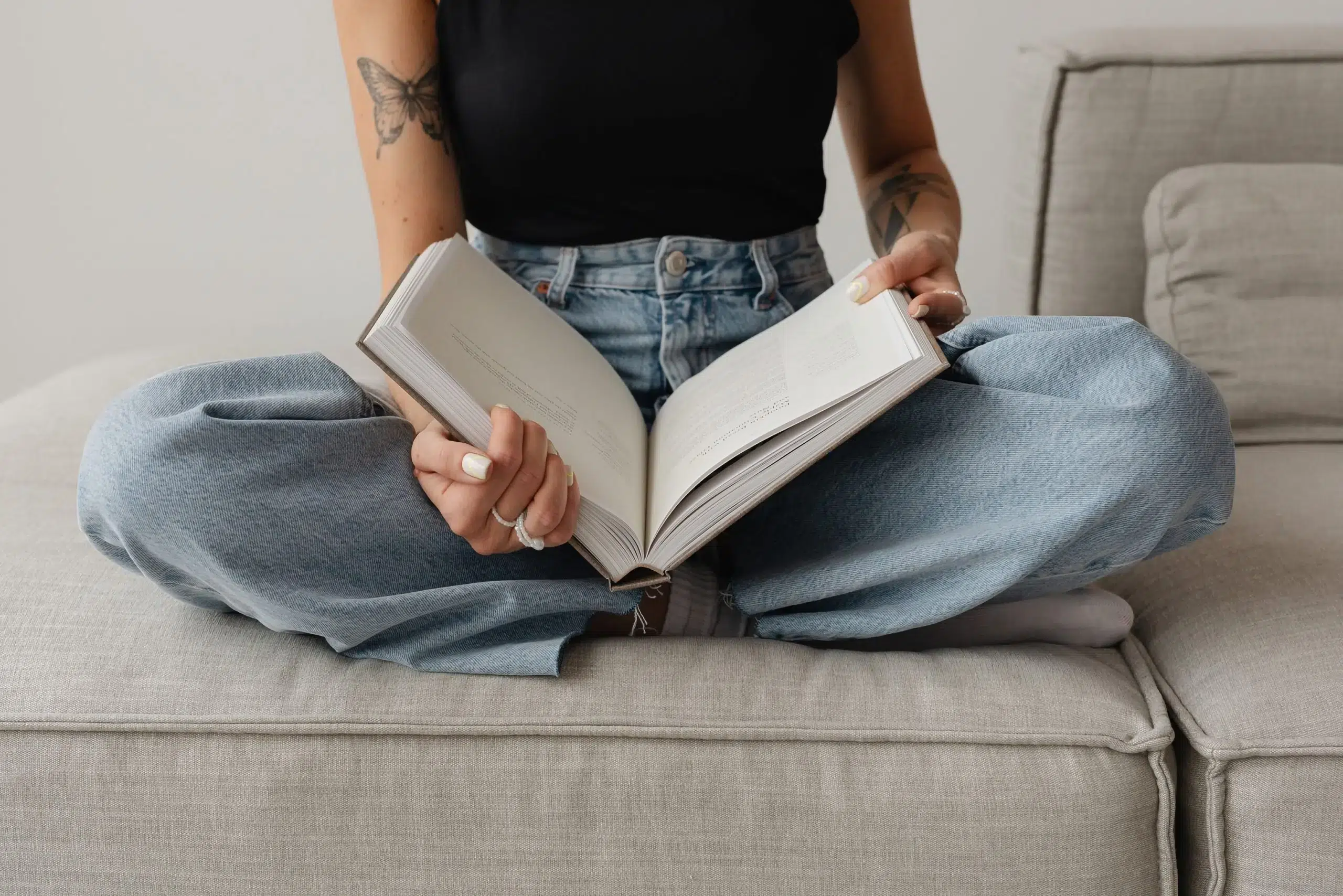 Eine Frau sitzt im Schneidersitz und hält ein großes Buch in den Händen.Das ist die Einleitung zu meinem Artikel „Marken-Glossar: 50 Branding-Begriffe einfach erklärt“.