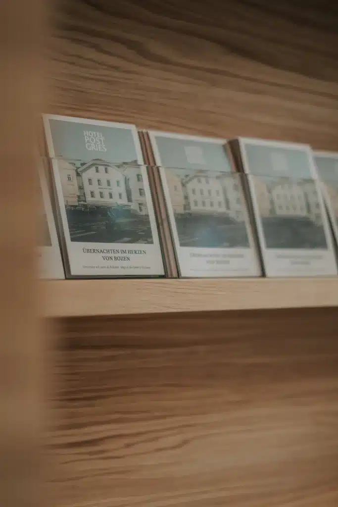 A shelf in the lobby of Hotel Post Gries displaying map-fold brochures designed by Nine Blaess