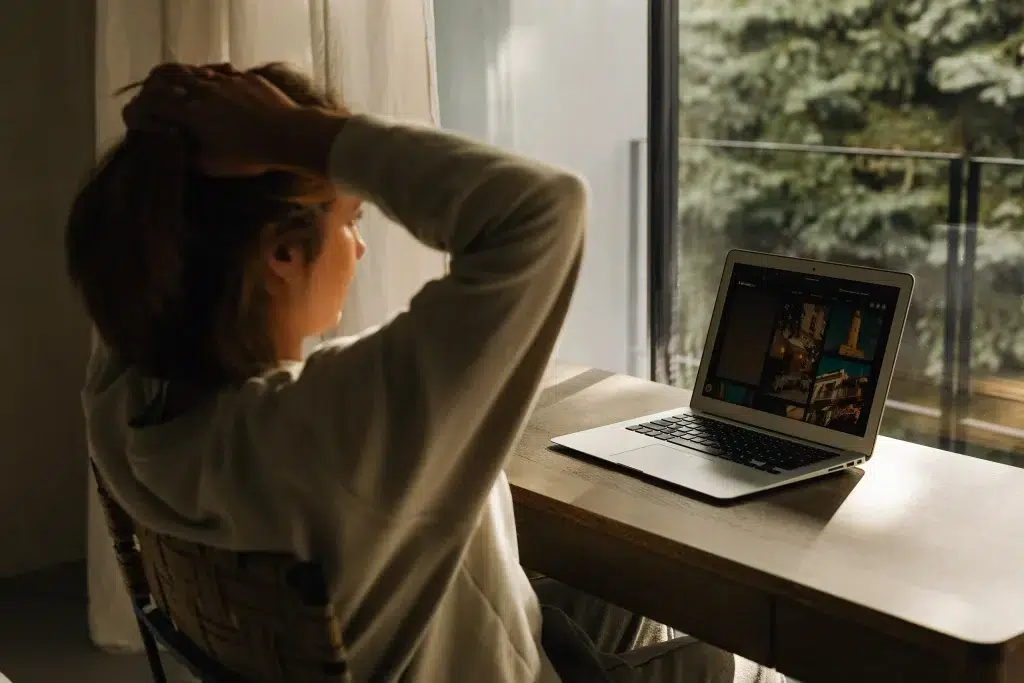 Eine Frau, die sich am Kopf kratzt und auf ihren Laptop schaut, als Einleitung zu meinem Artikel „20 Ideen, wie du deine Markenbekanntheit organisch aufbauen kannst”.