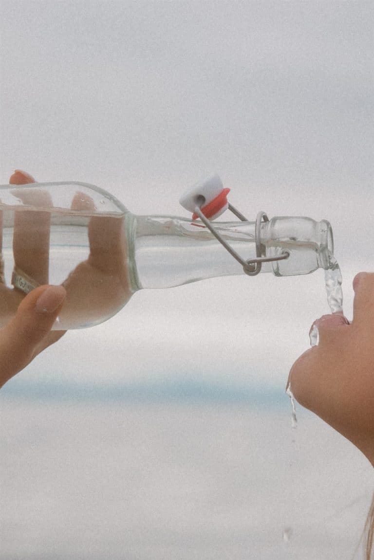 An example stock photo by Editorial Stock, which features a woman drinking from a glass bottle.