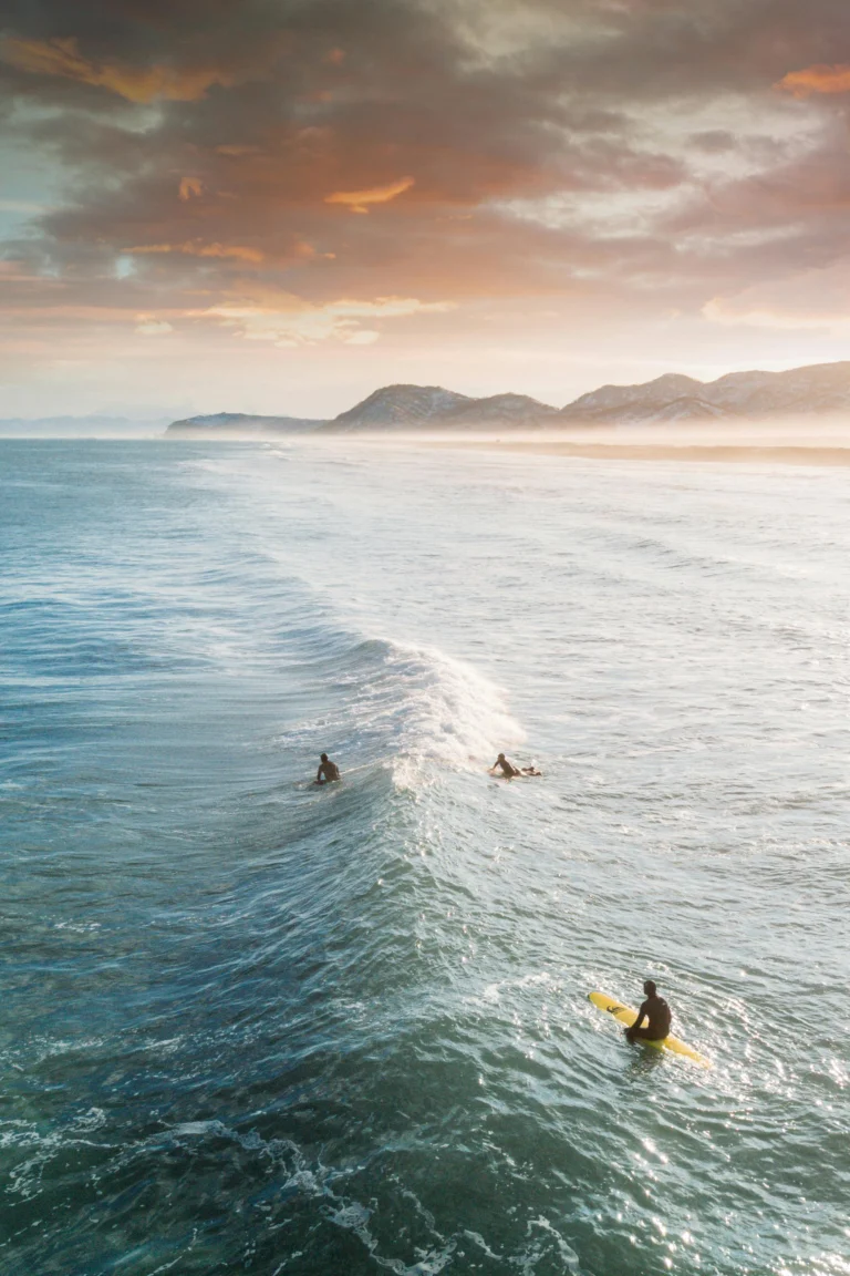 Three people surfing on ocean waves, example of adventurous lifestyle imagery available from top stock photo sites