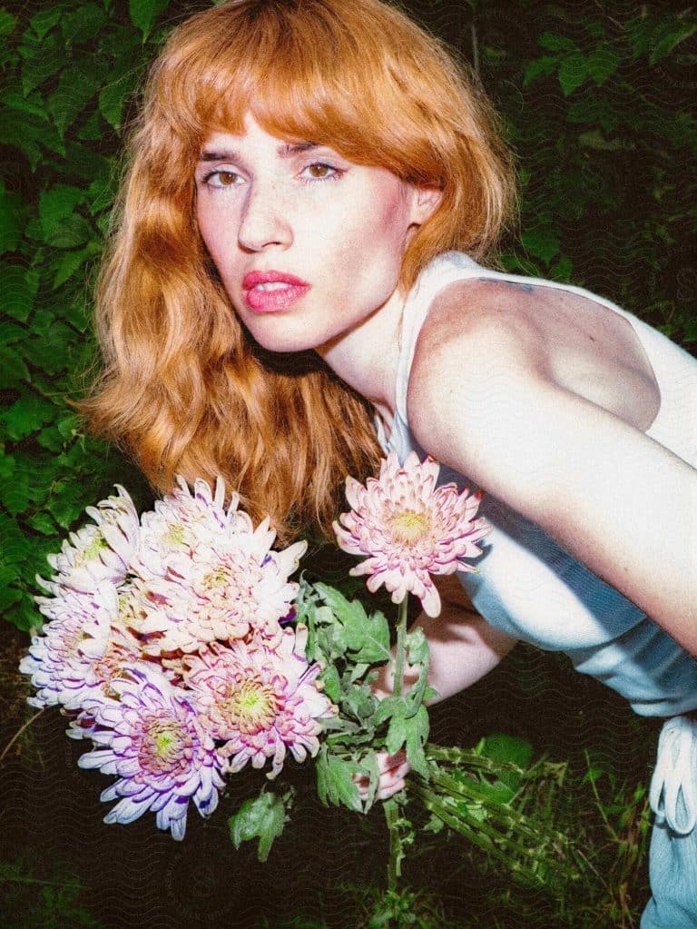Artistic portrait of woman with red hair and flowers by Lany Jade from Stills, cinematic stock photography