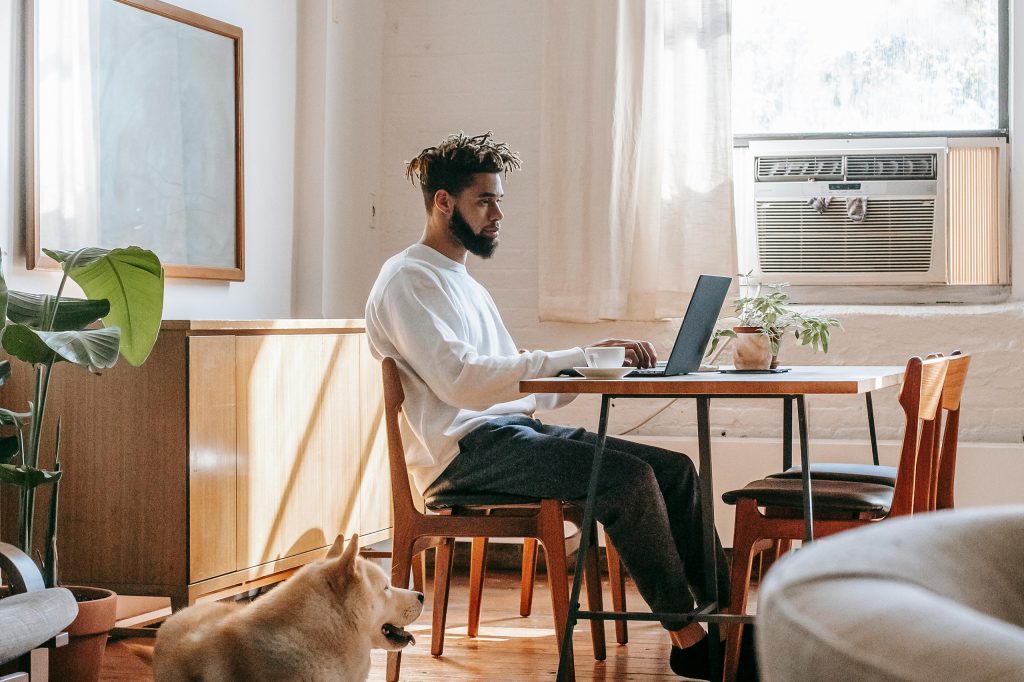 Person working on a laptop at a table, introducing an article about the psychology behind effective brand messaging.