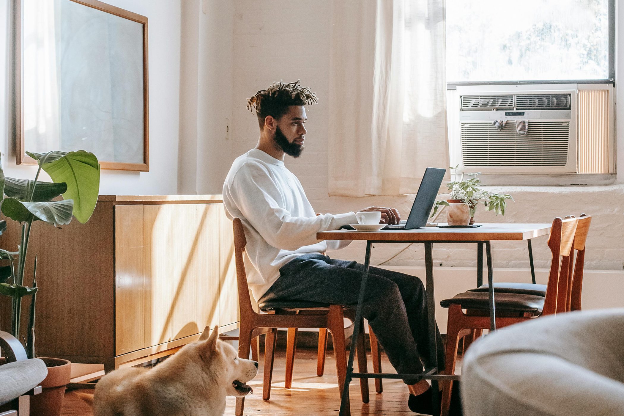 Person working on a laptop at a table, introducing an article about the psychology behind effective brand messaging.