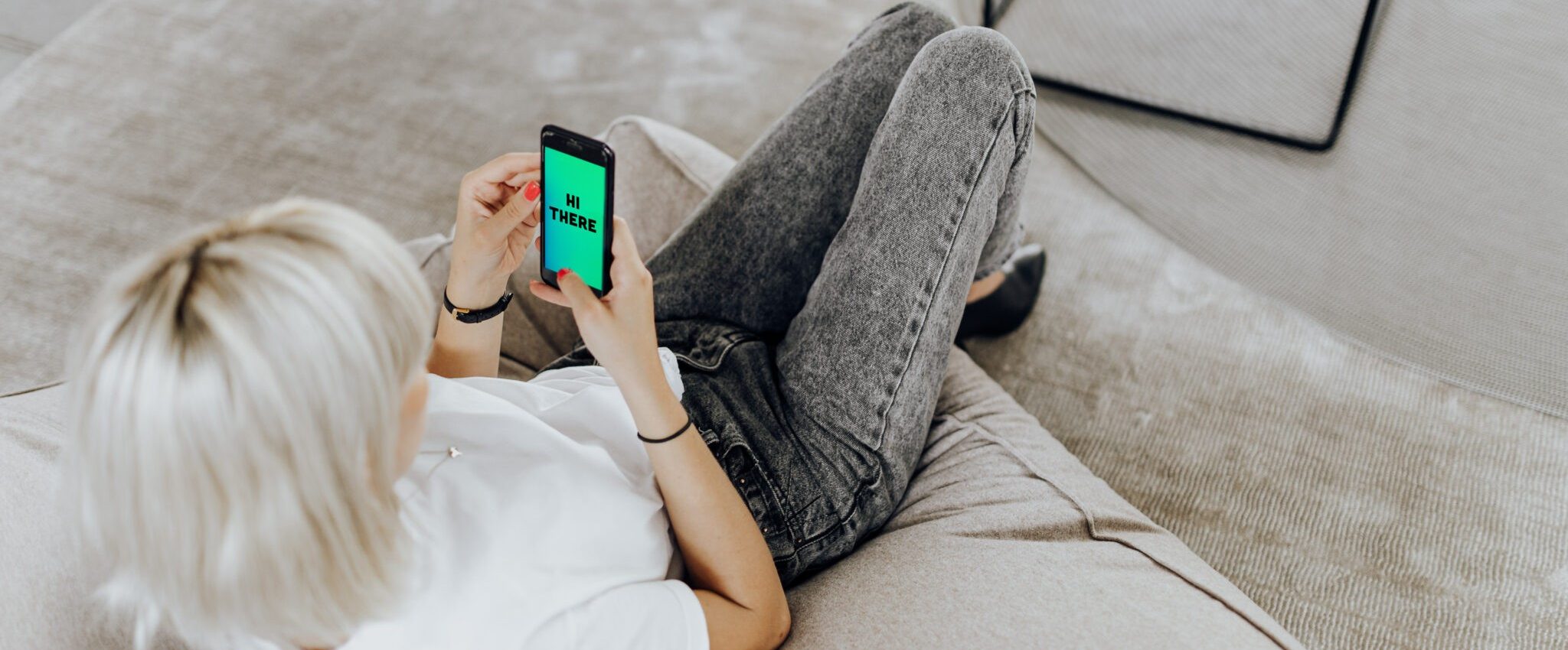 Woman looking at her mobile screen at a welcome message. This is an example of brand touchpoints