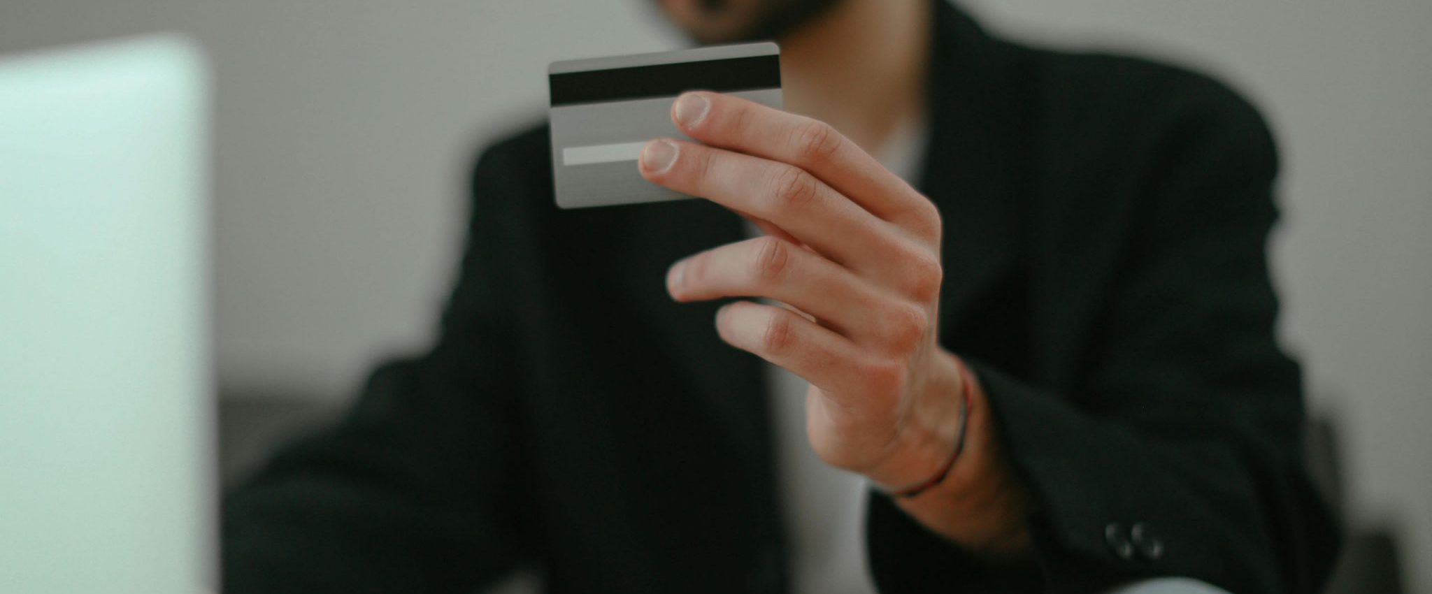 A man holding a credit card. This is the introduction to an article about 10 cognitive biases brands can leverage