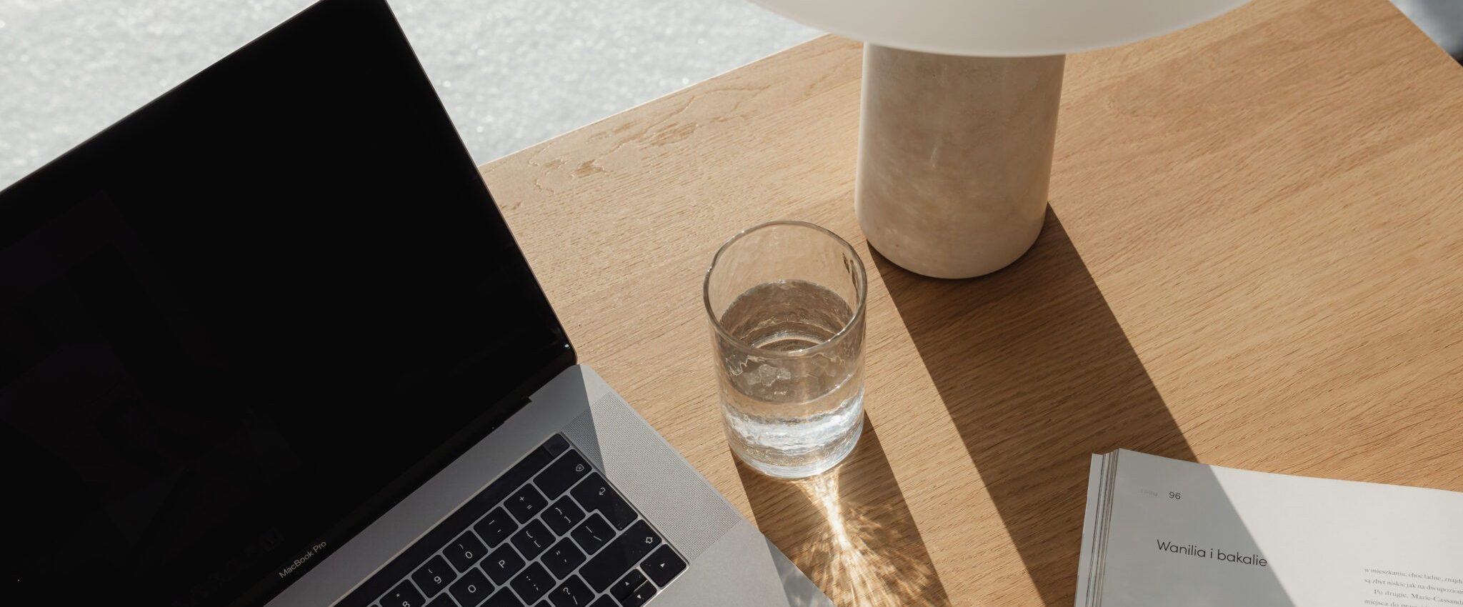 the image shoes a laptop, a lamp and a glass of water on a desk. It’s an introduction to the blog post "When is the best time for branding?"