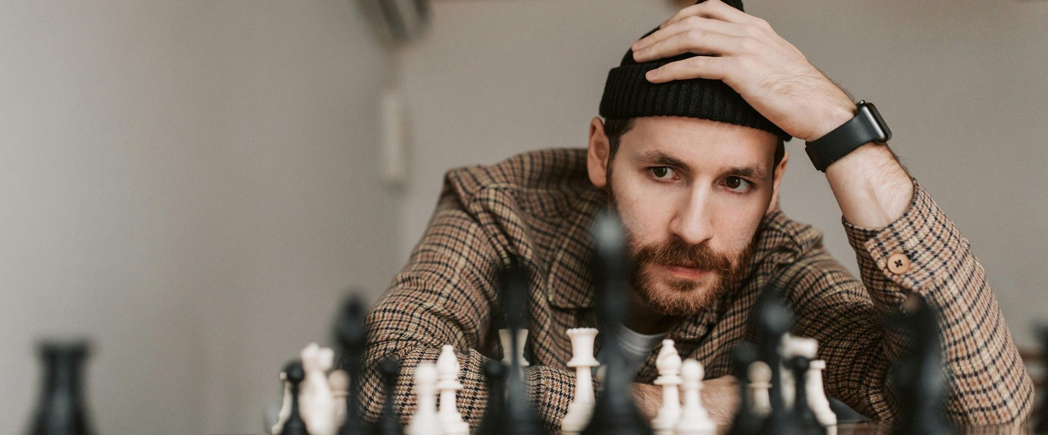 A man pondering about a chess field. This is the title image for an article on brand positioning, including plenty of brand positioning examples